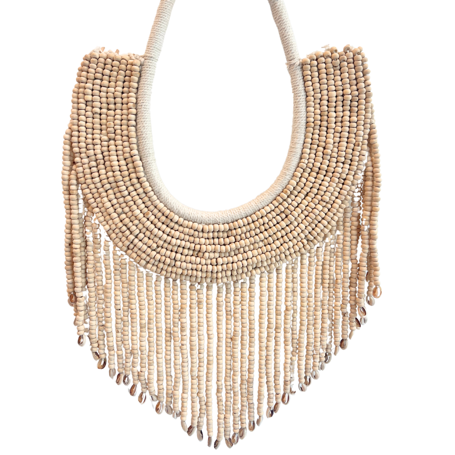 A handcrafted ivory-colored beaded wall hanging with a macrame backing and tiny cowrie shells, displayed against a plain background.
