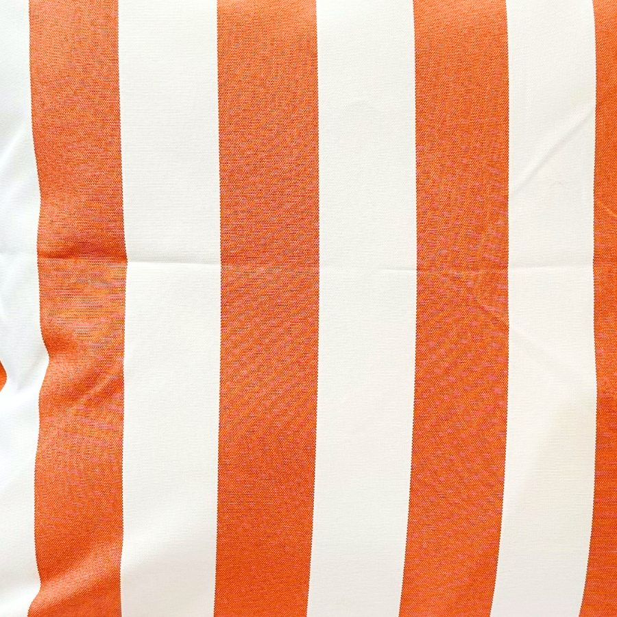 Close-up of a cushion with orange and white stripes on a white background.