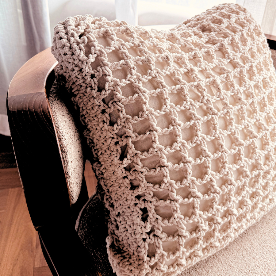 Beige knitted blanket draped over a chair.