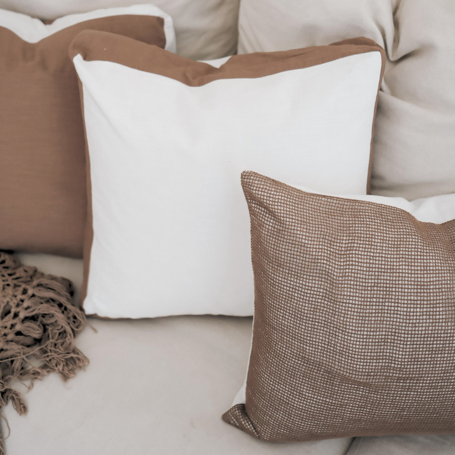 Decorative cushion on a sofa with a neutral color palette.