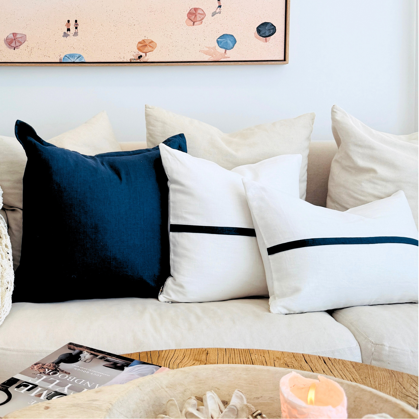 Cozy living room with a couch, decorative cushion, and a plant.