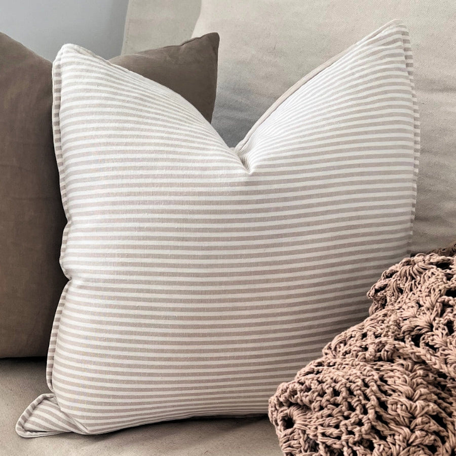 Cushions and blanket on a sofa.