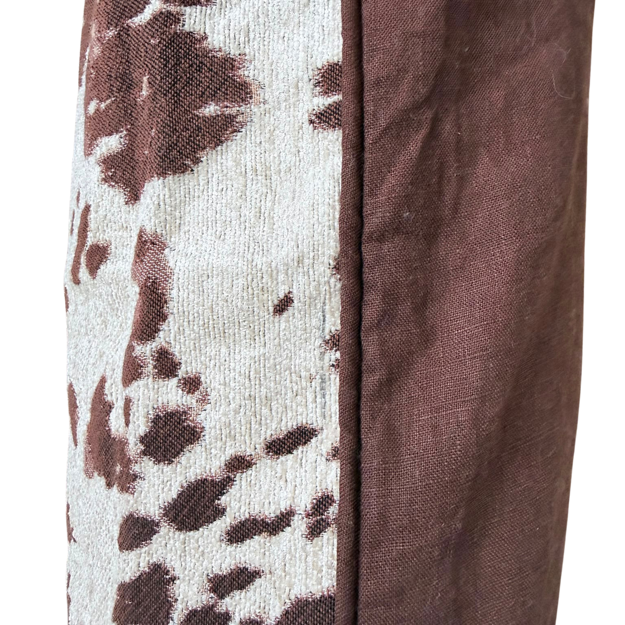 Close-up of a textile product showing a brown and off-white patterned side with a solid brown center seam.