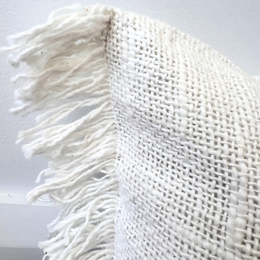 Woven style white cushion.