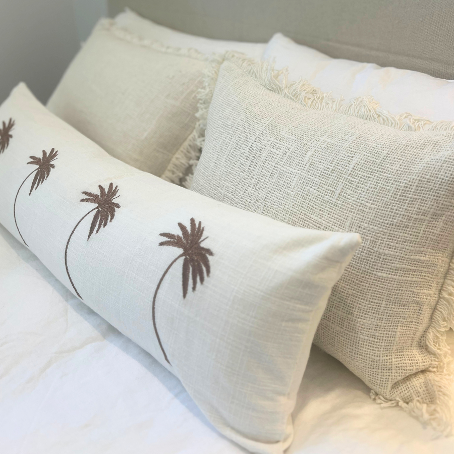 White cushions on a neatly prepared bed.