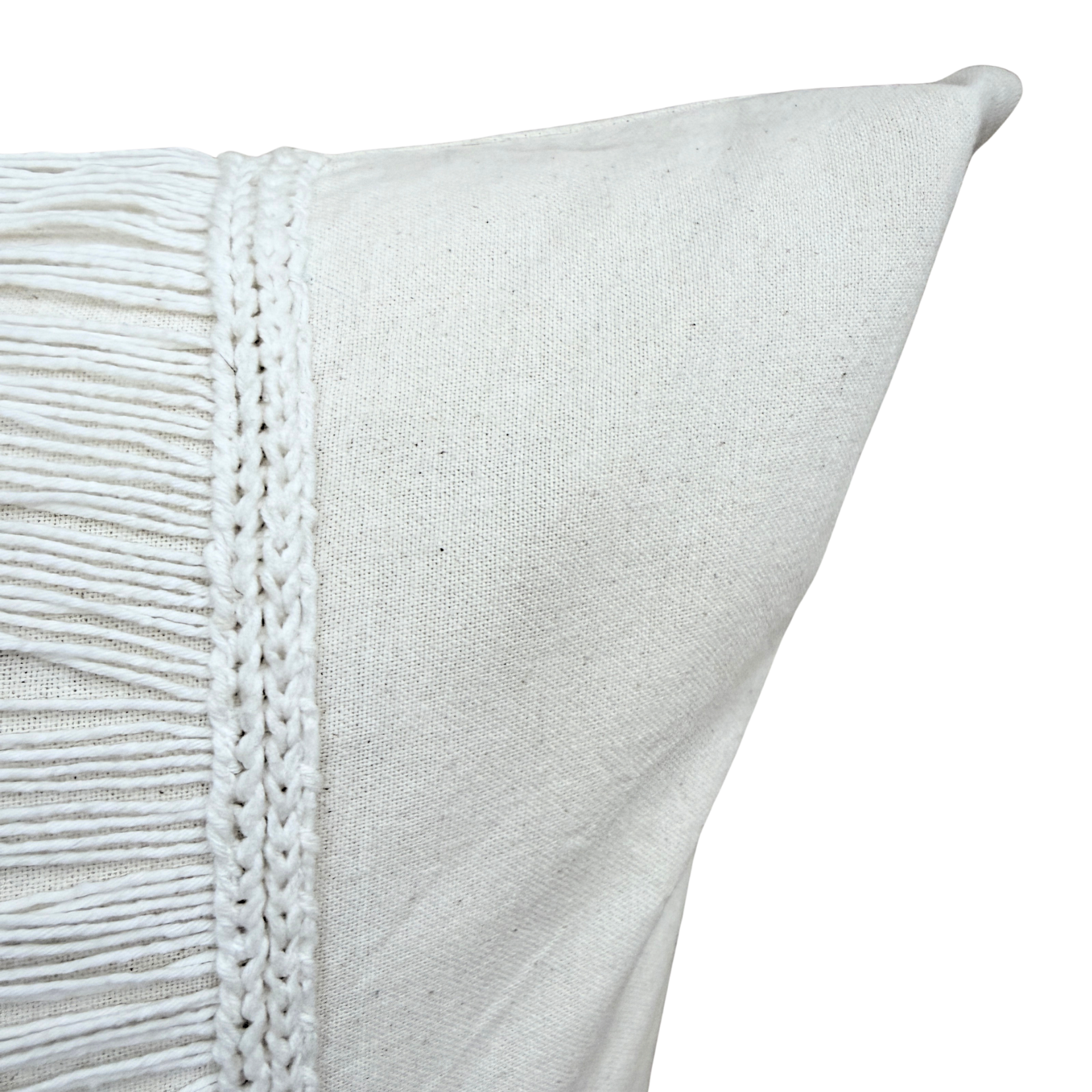 Close-up of a white cushion with fringe.