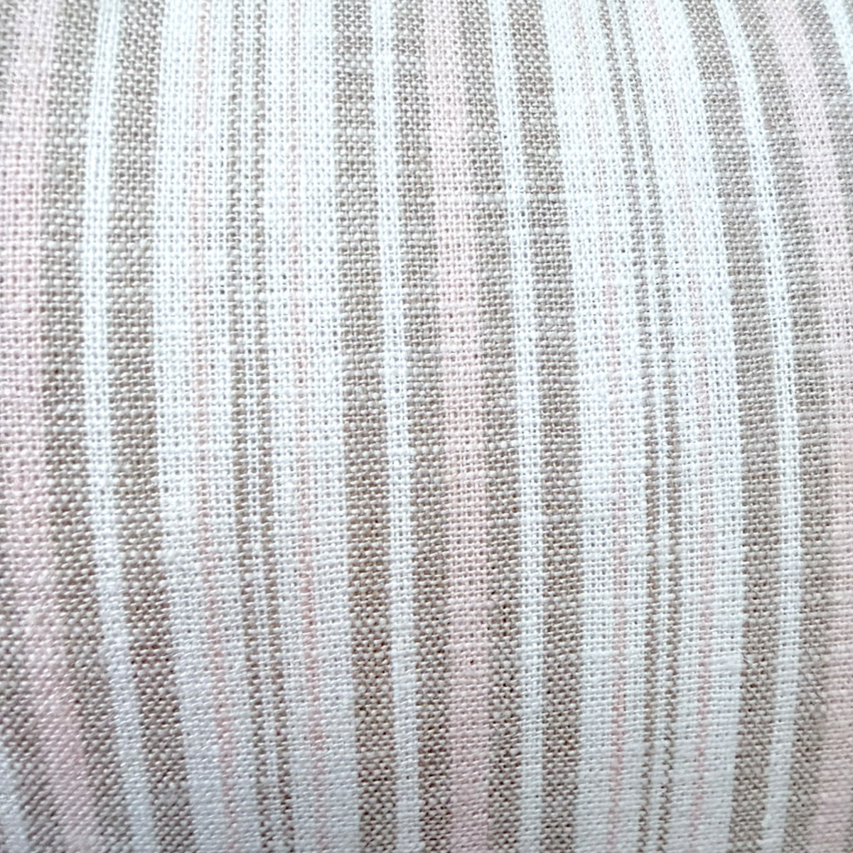Close-up of the soft linen material and vertical stripe pattern on a cushion.