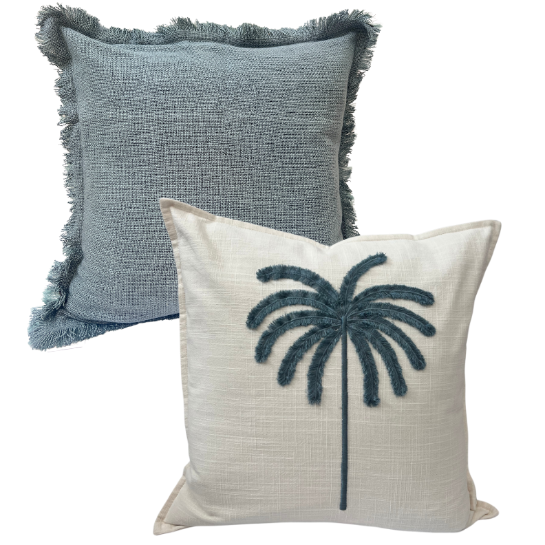 Two decorative cushions, one with a blue fringed cover and another with a white background featuring a blue tufted palm design.