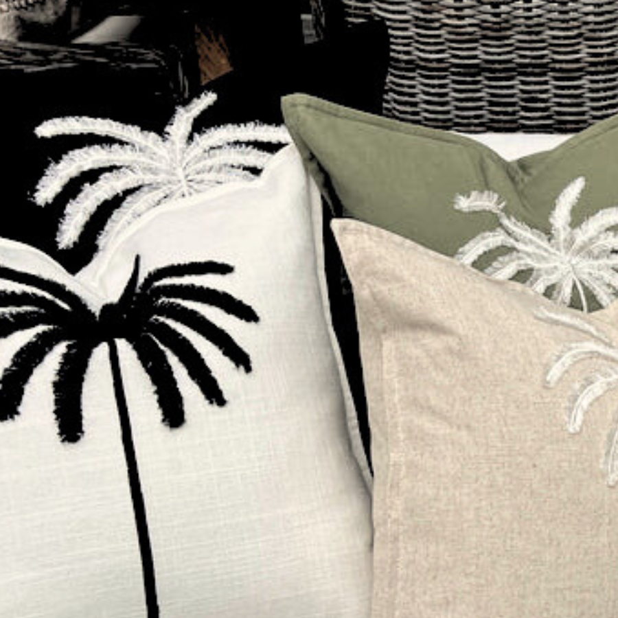 Four pillows designed with palm trees.