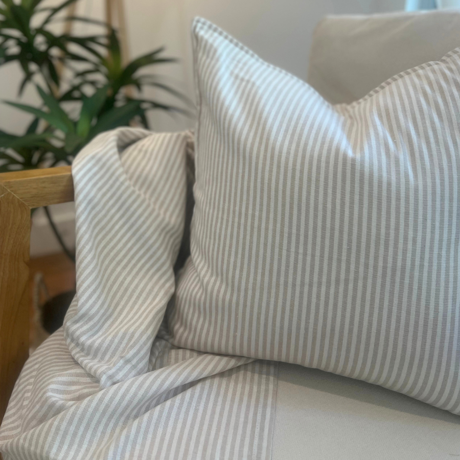 Striped cushion on a sofa with plant decor.