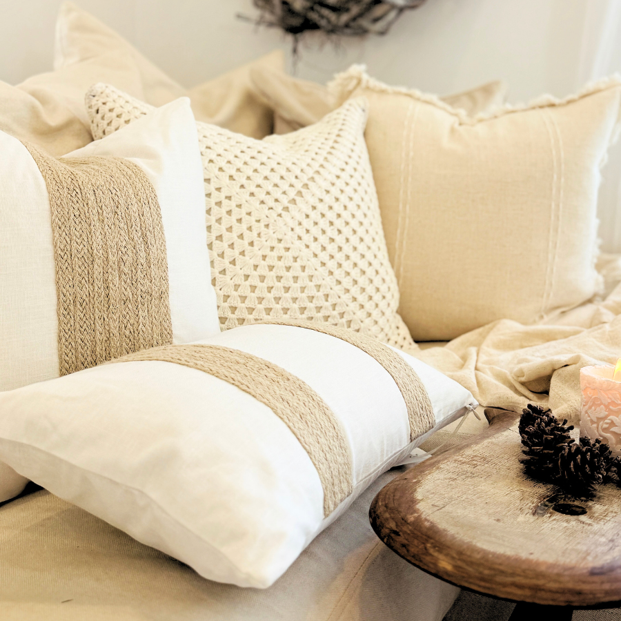 Decorative cushion on a sofa with a wreath and table.