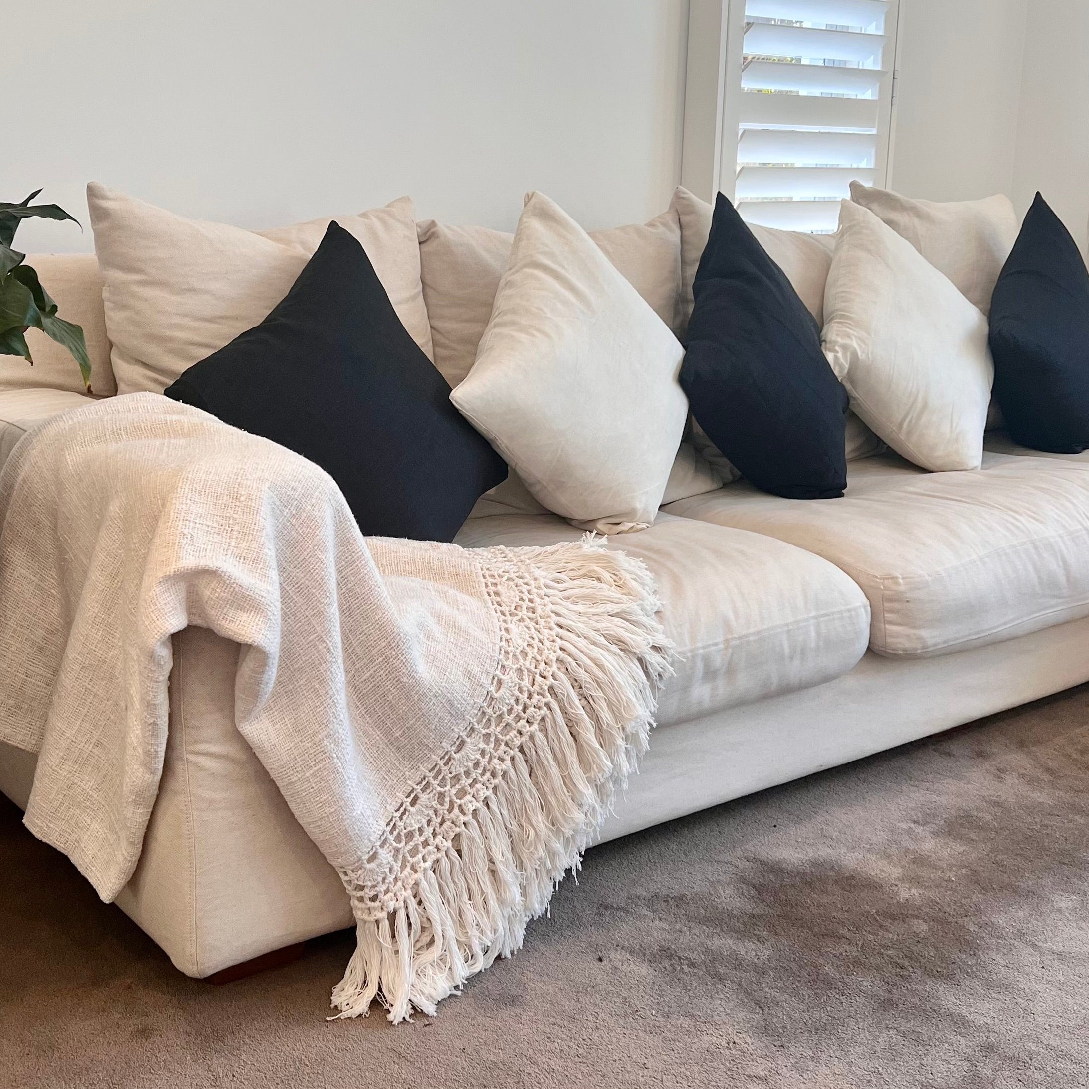 Cushions on a sofa with blanket.