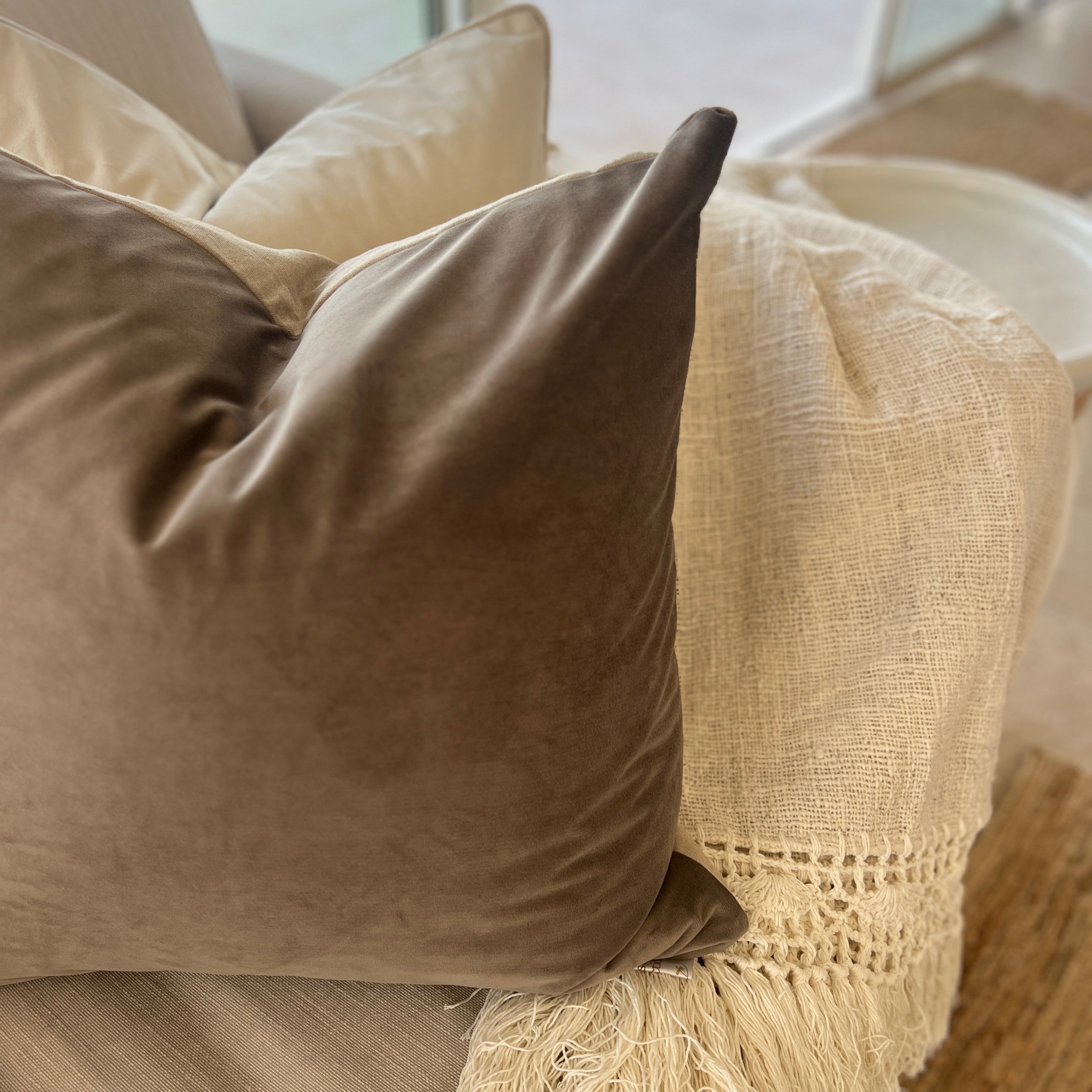 Cushions with blanket on a sofa.