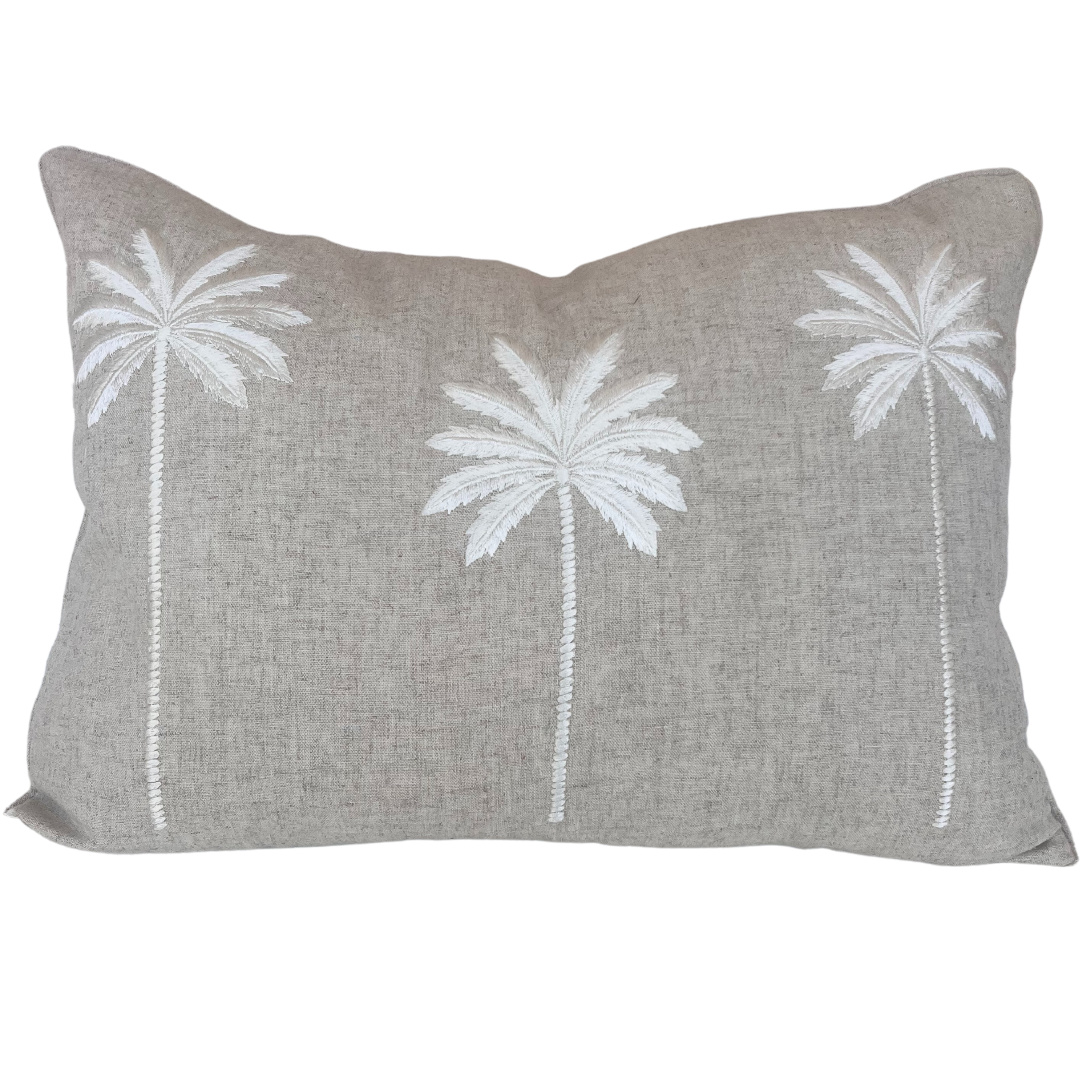 A natural-coloured linen cushion cover with three white embroidered palm trees and piped edges.